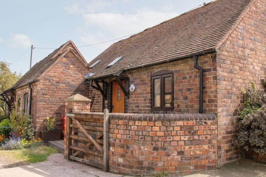 THE BYRE, character holiday cottage, with a garden in Leighton