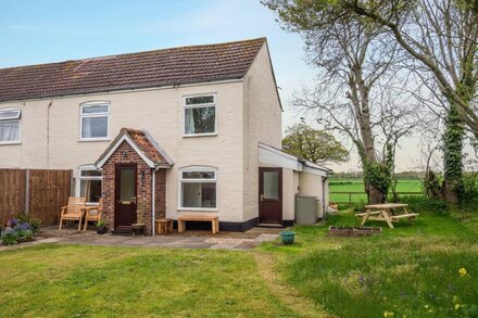 An end of terrace, farm cottage surrounded by countryside