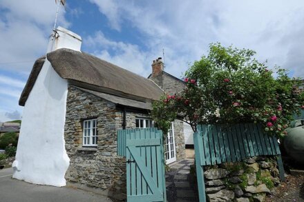 Charming  Listed Thatched Cottage with parking and short walk to sandy beach .