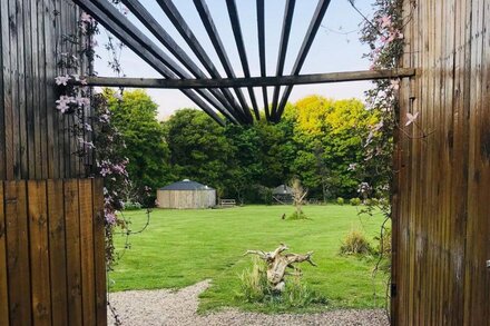 Eclipse, a furnished canvas bell tent in field and woodland surroundings