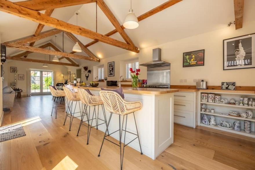 A superb, luxuriously appointed and exceptionally spacious barn conversion with private landscaped g