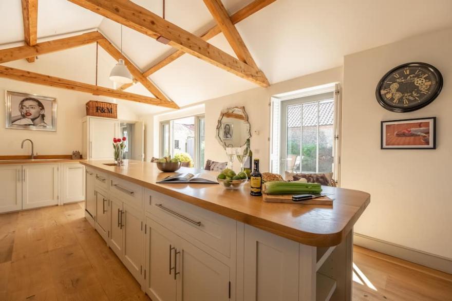 A superb, luxuriously appointed and exceptionally spacious barn conversion with private landscaped g