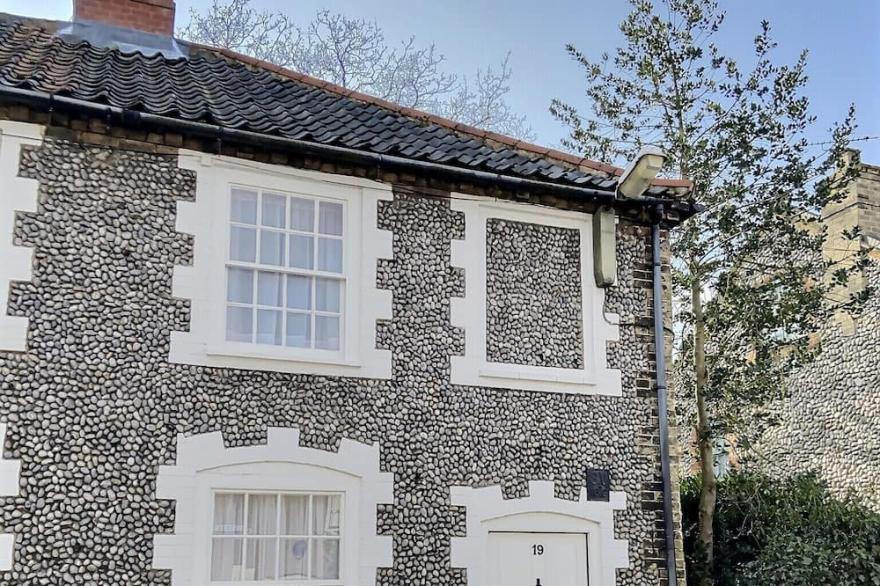 An iconic flint terraced cottage centrally located in the heart of Holt