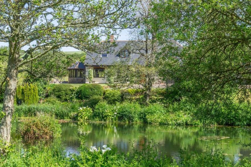 Overlooking the lakes of Roserrow, April Cottage is in an enviable location.