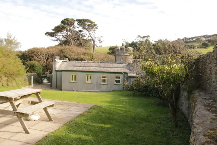 Turreted gatehouse to the historic Caerhays Castle located on the beach on the south Cornish Coast